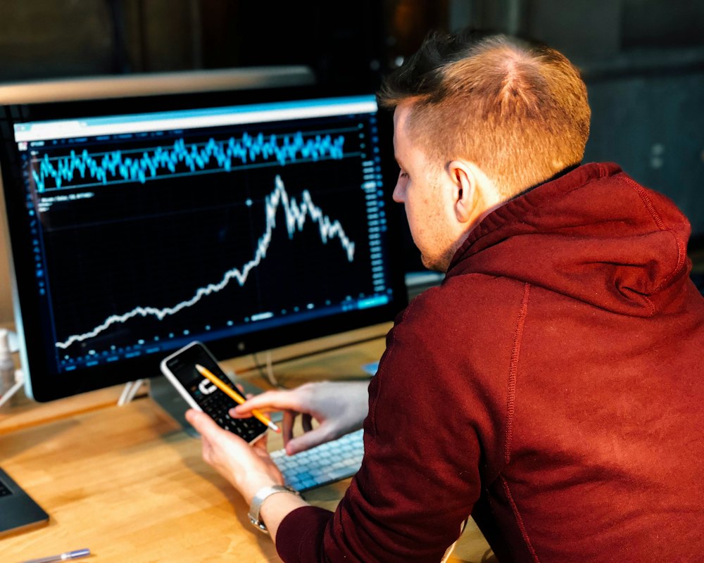 Trader studying candlestick charts on a large monitor
